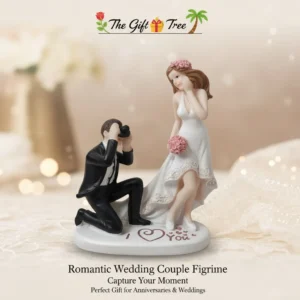 Celebrate Your Eternal Love Story Commemorate the magic of your special day with the Romantic Wedding Couple Figurine by The Gift Tree. This exquisitely detailed sculpture is designed to "Capture Your Moment," serving as a timeless reminder of the love and commitment shared between two souls. Key Features: Artistic 3D Design: Features a charming scene of a groom in a classic black tuxedo capturing a photo of his beautiful bride in a high-low lace wedding gown. Heartfelt Sentiments: The base is elegantly inscribed with "I ❤️ You" and delicate pink heart accents, making it a truly "Romantic" keepsake. Exquisite Detailing: From the bride’s pink floral headpiece and matching bouquet to the groom’s realistic camera, every element is meticulously crafted. Perfect for Anniversaries & Weddings: This figurine is the "Perfect Gift for Anniversaries & Weddings," offering a unique alternative to traditional presents. Premium Decor Piece: Set on a clean white oval base, it adds a touch of elegance to your mantel, bedside table, or display cabinet.